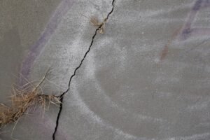 Cracked concrete slab showing signs that could indicate a slab leak under a Spring TX home